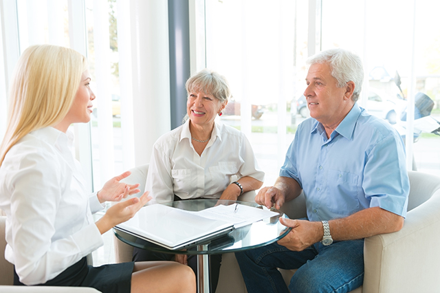 older couple discussing term vs. whole life insurance with an agent