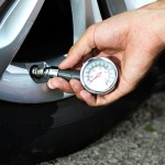 driver testing the tire pressure