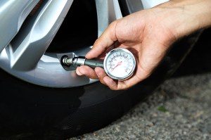 driver testing the tire pressure