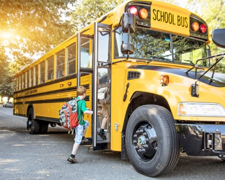 young kid boarding a school bus - when to stop for a school bus