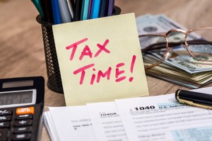 messy desk with tax forms and calculator