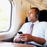 man sitting down listening to a podcast through her device