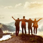 group of friends overlooking the mountains after hiking to a lookout point