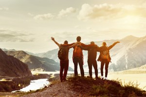 group of friends overlooking the mountains after hiking to a lookout point