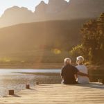 snowbirds - older couple enjoying retirement sitting on a dock looking at the water