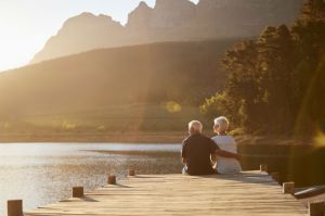 snowbirds - older couple enjoying retirement sitting on a dock looking at the water