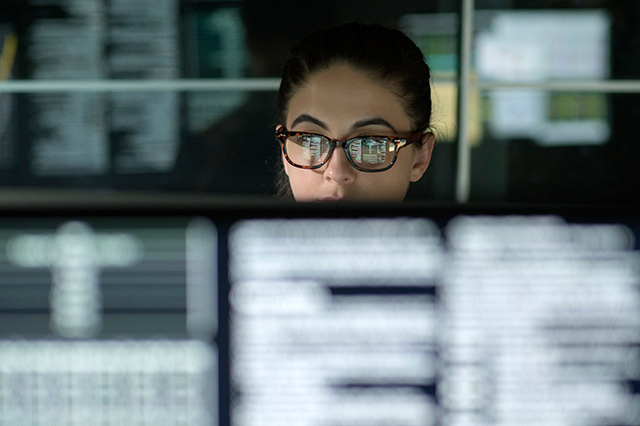 Woman with data on multiple monitors