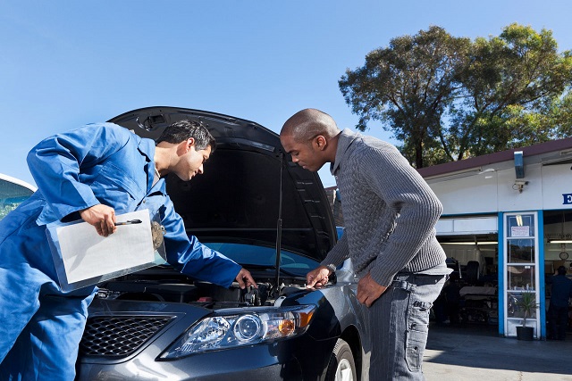 Mechanic talking to customer about car 