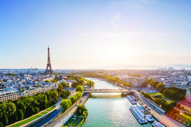 Paris aerial panorama with river Seine and Eiffel tower, France. Romantic summer holidays vacation destination. Panoramic view above historical Parisian buildings and landmarks with blue sky and sun