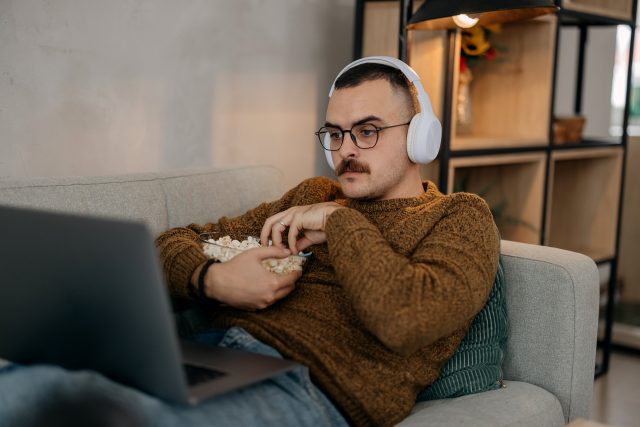 man eating popcorn with headphones